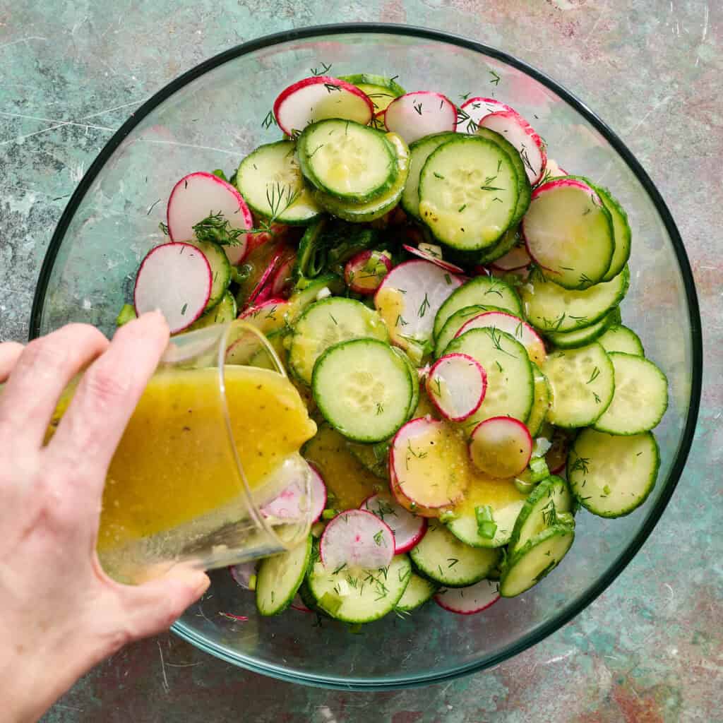 adding dressing to the salad