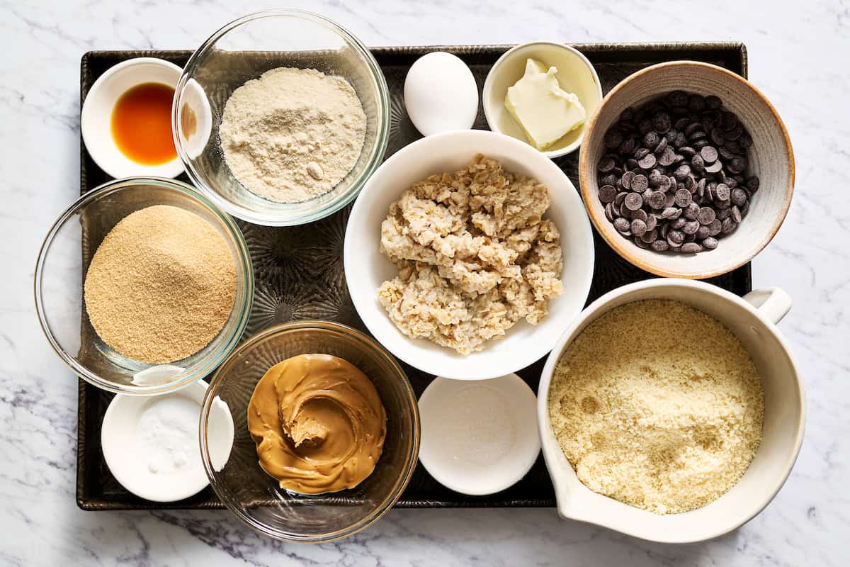 ingredients to make leftover oatmeal cookies including oatmeal, almond flour, almond butter, baking soda, coconut flour, sweetener, egg and butter