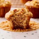 Sourdough discard banana nut muffins with golden domed tops and a bite taken out to show fluffy interior