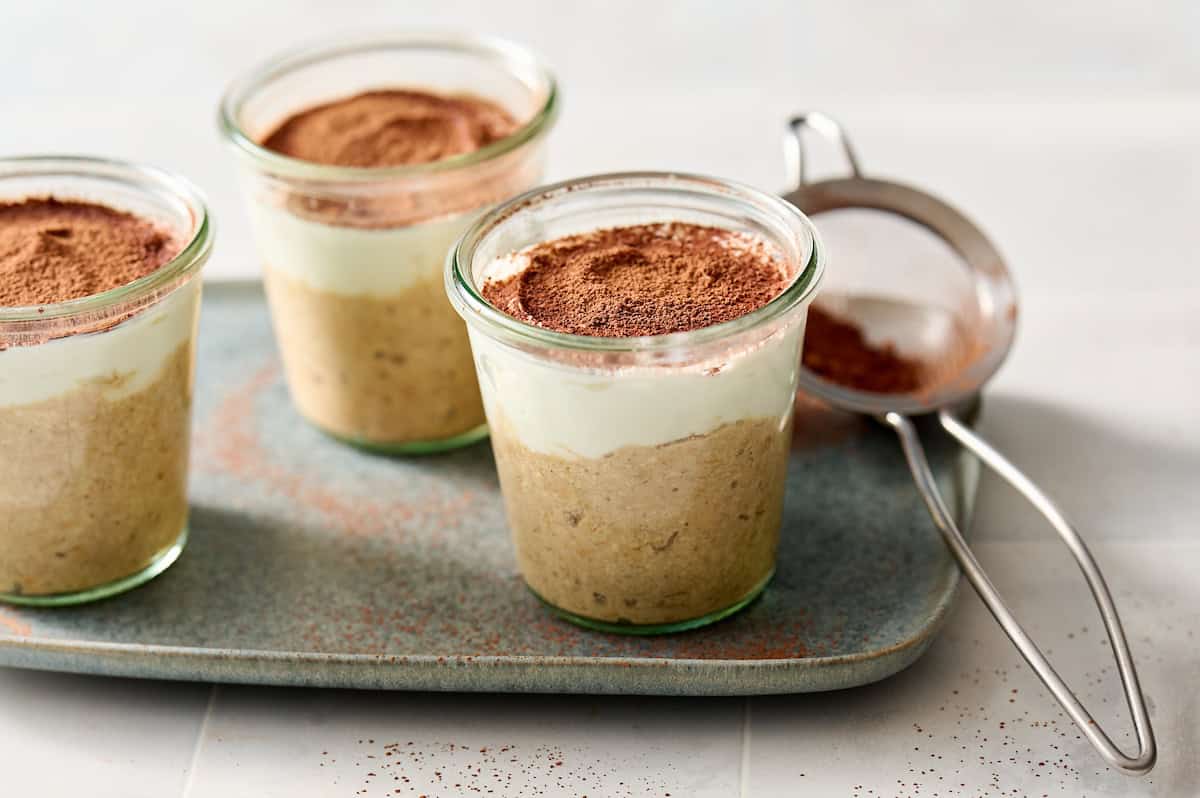 tiramisu overnight oats with ricotta in jars with cocoa powder on the side