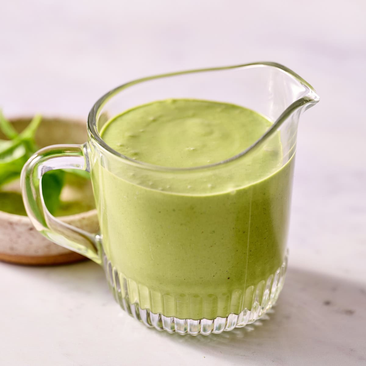 basil lime dressing in a glass cup
