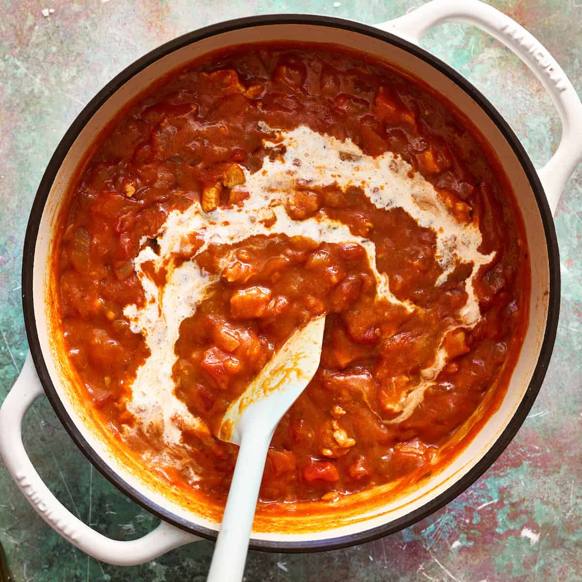 adding cream to the pot of soup