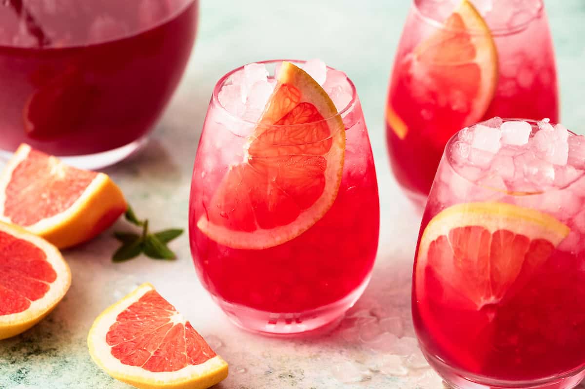 mocktails on a countertop with a large pitcher for batch servings