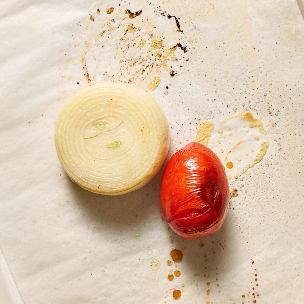 roasted onion and tomato on a baking sheet