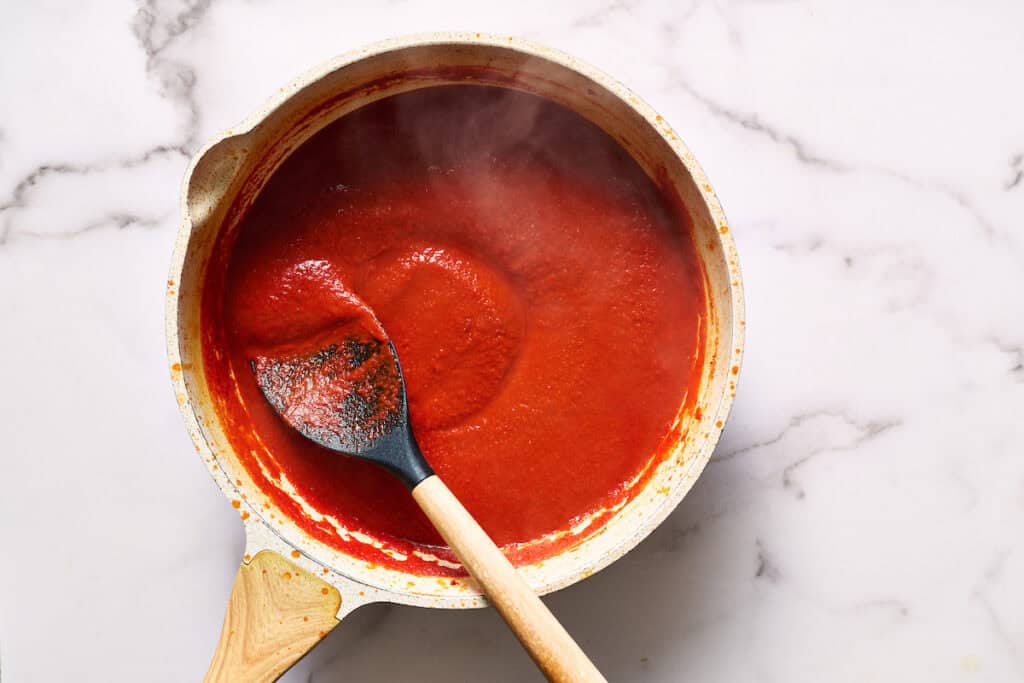 steam rising from simmered sauce in a saute pan