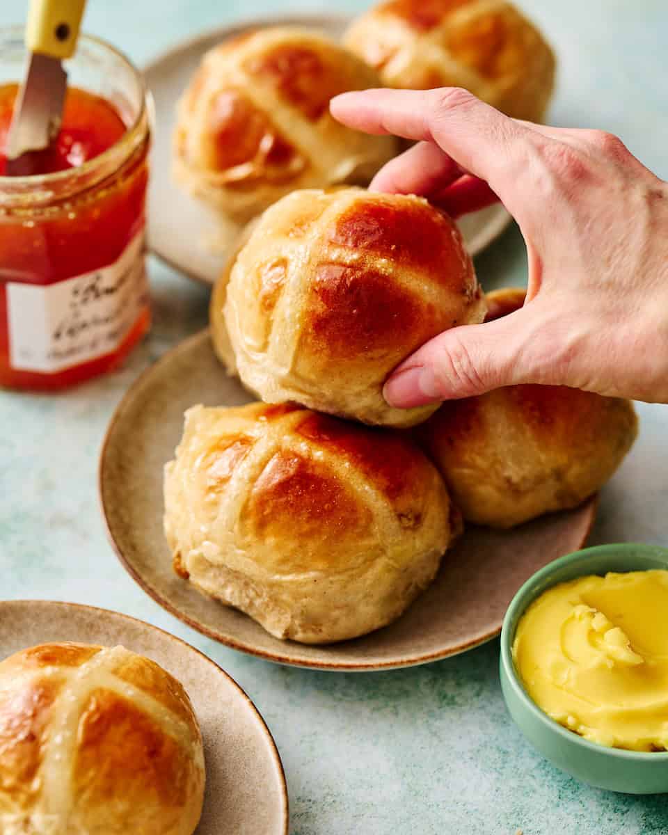 hand reaching in to take a hot cross bun